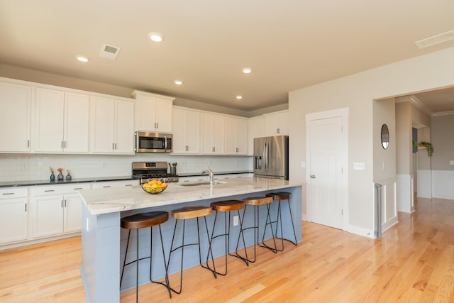 3328 Prairie Range Ln, Apison, TN 37302 - kitchen featuring stainless steel appliances, light wood-style flooring, decorative backsplash, a kitchen breakfast bar, and recessed lighting