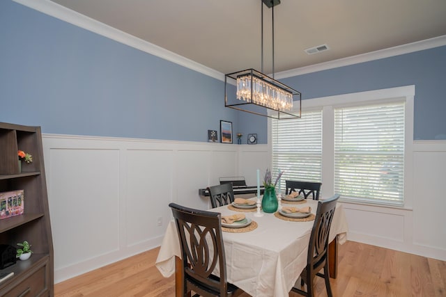3328 Prairie Range Ln, Apison, TN 37302 - dining area with a decorative wall, a chandelier, ornamental molding, light wood-style flooring, and wainscoting