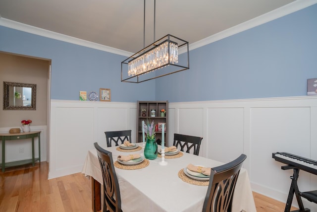 3328 Prairie Range Ln, Apison, TN 37302 - dining area with ornamental molding, a chandelier, light wood-style floors, wainscoting, and a decorative wall