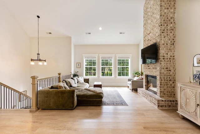 7596 Grasshopper Rd, Georgetown, TN 37336 - living room featuring light wood-type flooring, a chandelier, and a fireplace
