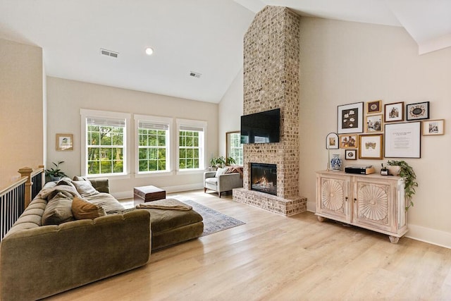 7596 Grasshopper Rd, Georgetown, TN 37336 - living area with high vaulted ceiling, light wood-style flooring, and a brick fireplace
