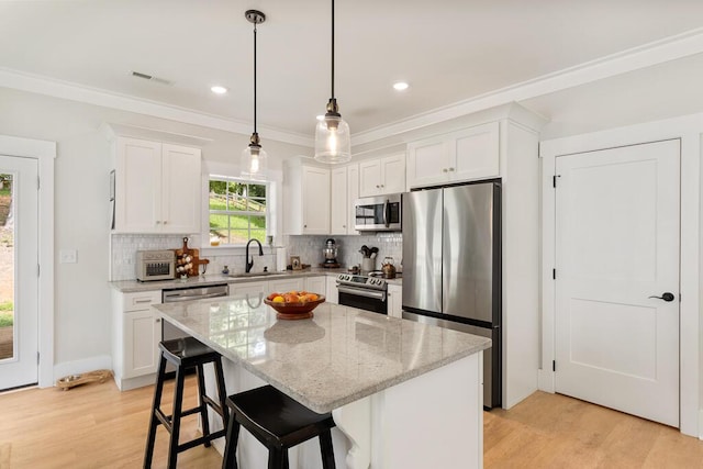 7596 Grasshopper Rd, Georgetown, TN 37336 - kitchen featuring appliances with stainless steel finishes, tasteful backsplash, white cabinets, light stone countertops, and light wood-type flooring