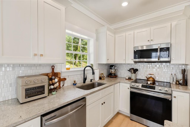 7596 Grasshopper Rd, Georgetown, TN 37336 - kitchen with appliances with stainless steel finishes, white cabinets, light stone counters, backsplash, and light wood finished floors