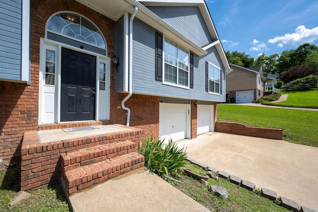 6220 Hunter Valley Rd, Ooltewah, TN 37363 - doorway to property with concrete driveway, a lawn, an attached garage, and brick siding