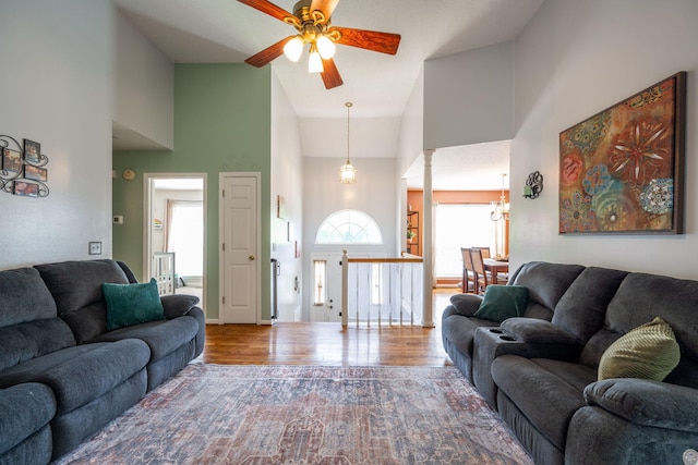 6220 Hunter Valley Rd, Ooltewah, TN 37363 - living room featuring high vaulted ceiling, ceiling fan, wood finished floors, and a chandelier