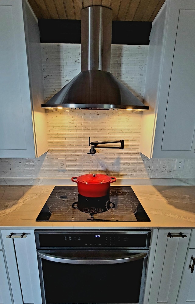 1131 Stringers Ridge Rd Unit 12H, Chattanooga, TN 37405 - kitchen with wall chimney exhaust hood, black appliances, decorative backsplash, light countertops, and wooden ceiling