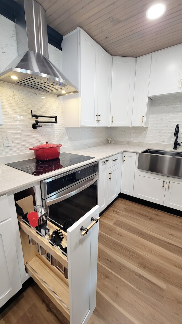 1131 Stringers Ridge Rd Unit 12H, Chattanooga, TN 37405 - kitchen with wall chimney range hood, stainless steel oven, decorative backsplash, wooden ceiling, and light countertops