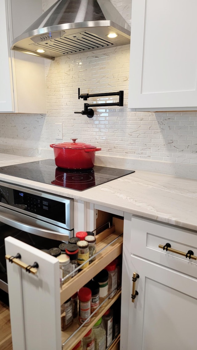 1131 Stringers Ridge Rd Unit 12H, Chattanooga, TN 37405 - kitchen with range hood, backsplash, white cabinetry, and light stone counters