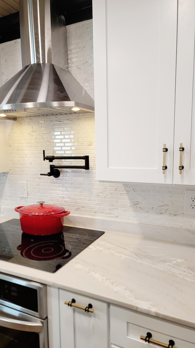 1131 Stringers Ridge Rd Unit 12H, Chattanooga, TN 37405 - kitchen featuring wall chimney exhaust hood, oven, tasteful backsplash, white cabinets, and black electric stovetop