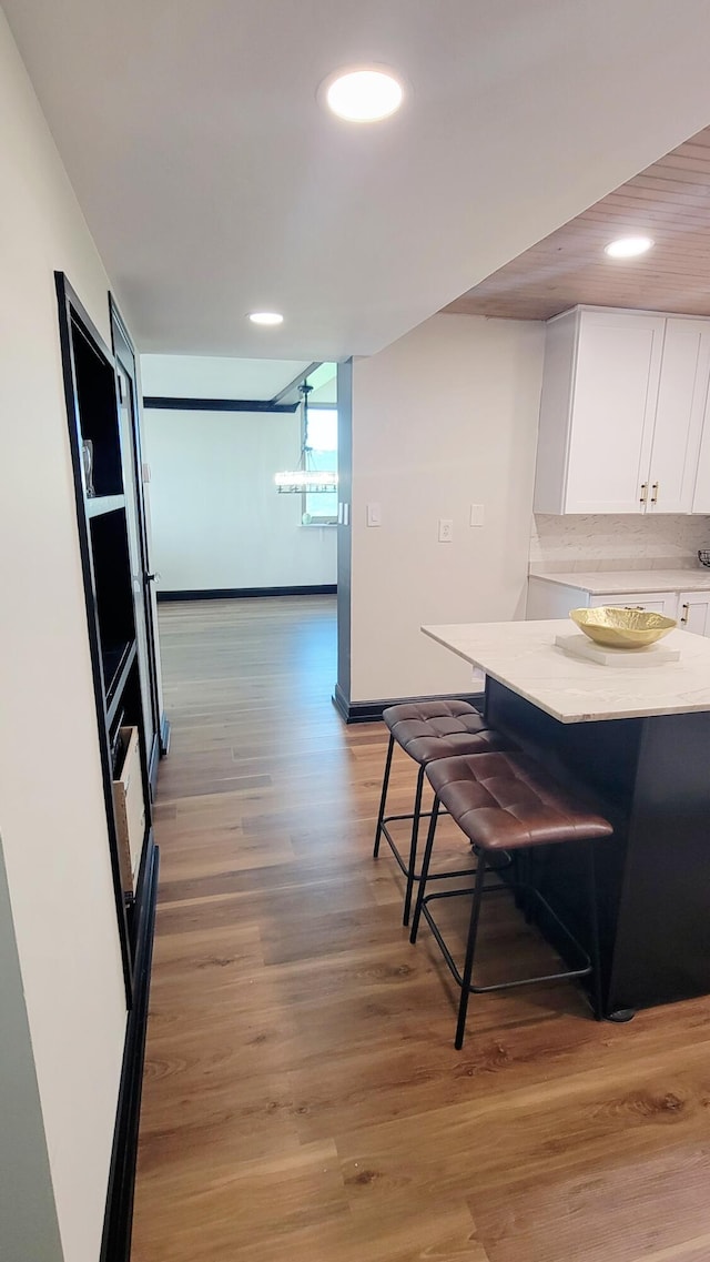 1131 Stringers Ridge Rd Unit 12H, Chattanooga, TN 37405 - kitchen with white cabinets, a kitchen bar, light countertops, light wood-type flooring, and recessed lighting