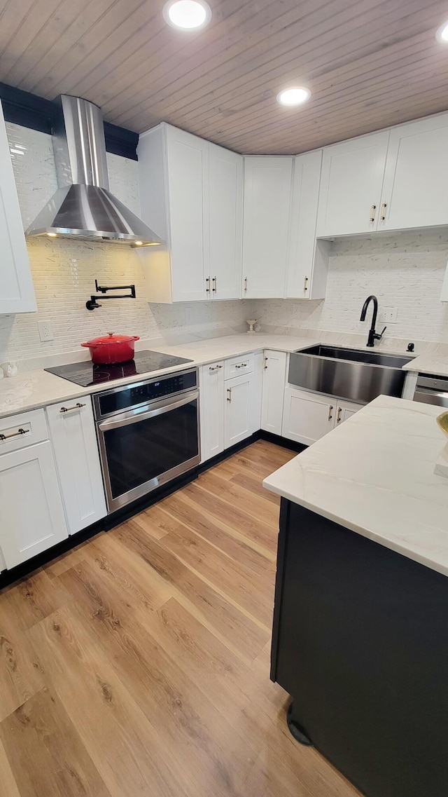 1131 Stringers Ridge Rd Unit 12H, Chattanooga, TN 37405 - kitchen with stainless steel oven, wall chimney range hood, wood ceiling, backsplash, and white cabinets