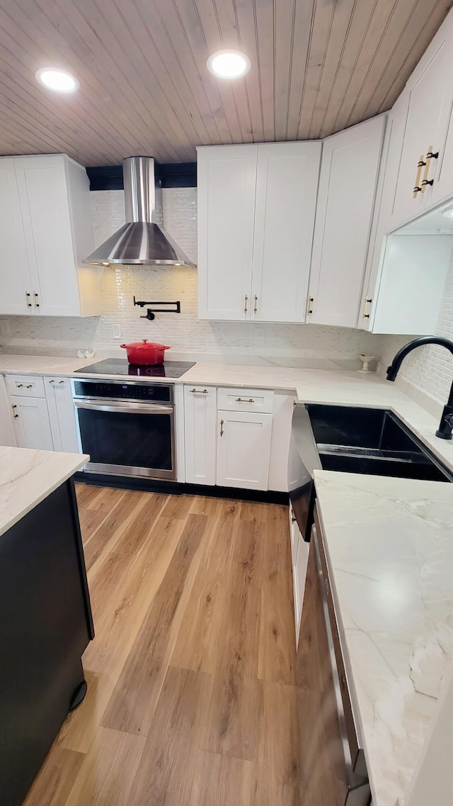 1131 Stringers Ridge Rd Unit 12H, Chattanooga, TN 37405 - kitchen featuring oven, wall chimney range hood, wood ceiling, black electric cooktop, and light wood finished floors