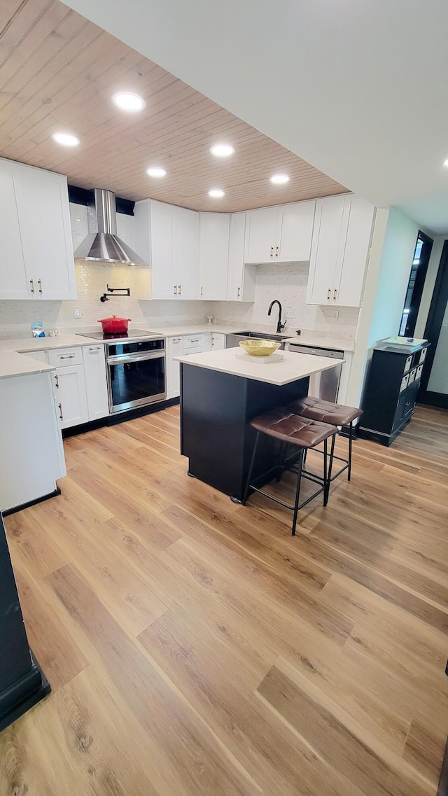 1131 Stringers Ridge Rd Unit 12H, Chattanooga, TN 37405 - kitchen featuring wall chimney exhaust hood, light countertops, white cabinetry, backsplash, and recessed lighting
