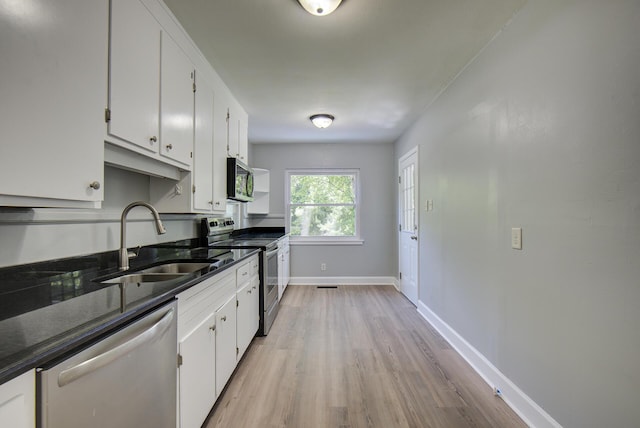 1728 John Ross Rd, Chattanooga, TN 37412 - kitchen with stainless steel appliances, light wood finished floors, white cabinets, and dark stone counters