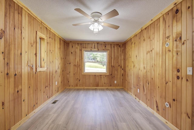 1728 John Ross Rd, Chattanooga, TN 37412 - spare room featuring light wood-style flooring, a ceiling fan, wood walls, and a textured ceiling