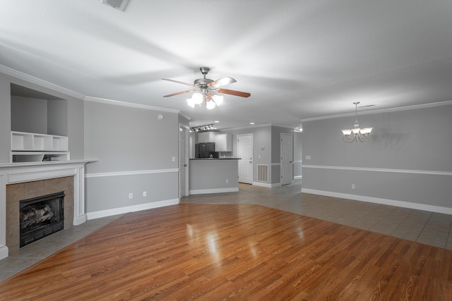 802 Applebrook Dr Unit 802, Rossville, GA 30741 - unfurnished living room featuring a tiled fireplace, a ceiling fan, crown molding, a chandelier, and wood finished floors