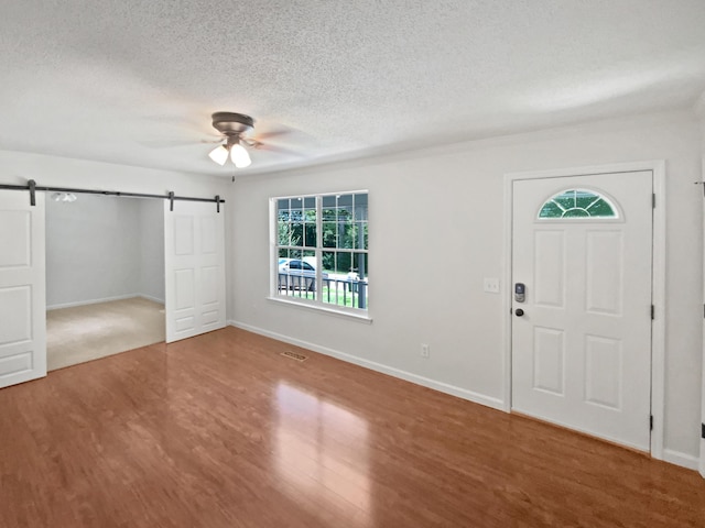 7110 Ridgestone Dr, Ooltewah, TN 37363 - entrance foyer featuring a barn door, healthy amount of natural light, a textured ceiling, wood finished floors, and a ceiling fan