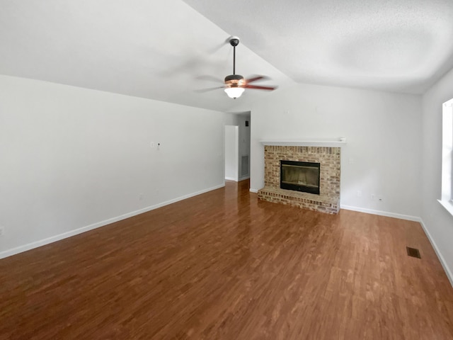 7110 Ridgestone Dr, Ooltewah, TN 37363 - unfurnished living room featuring wood finished floors, ceiling fan, vaulted ceiling, and a brick fireplace