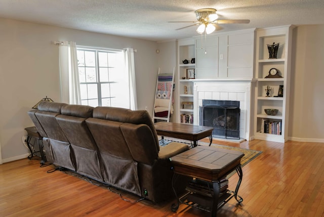 732 Salem Rd, Rossville, GA 30741 - living room featuring a fireplace, ceiling fan, light wood-type flooring, built in features, and a textured ceiling
