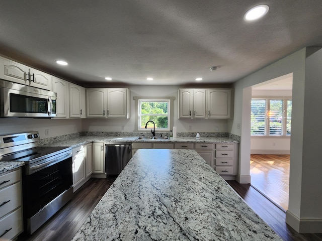 1 Magnolia St, Niota, TN 37826 - kitchen featuring stainless steel appliances, light stone countertops, dark wood-style flooring, recessed lighting, and white cabinets