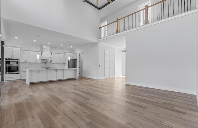 10541 E Brainerd Rd, Apison, TN 37302 - unfurnished living room with light wood-style flooring, a towering ceiling, and recessed lighting