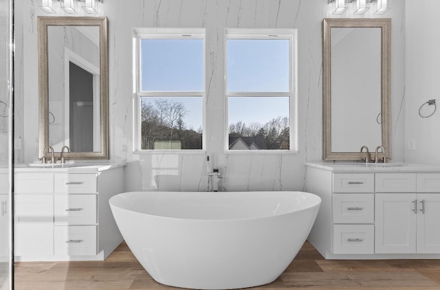 10541 E Brainerd Rd, Apison, TN 37302 - full bathroom featuring two vanities, a soaking tub, and wood finished floors