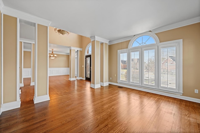 6401 Beacon Pointe Cir, Hixson, TN 37343 - unfurnished living room featuring a chandelier, decorative columns, hardwood / wood-style floors, and crown molding