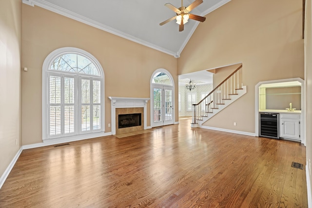 6401 Beacon Pointe Cir, Hixson, TN 37343 - unfurnished living room with wine cooler, high vaulted ceiling, healthy amount of natural light, a tile fireplace, and bar area