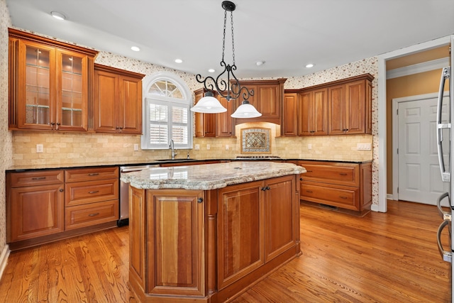 6401 Beacon Pointe Cir, Hixson, TN 37343 - kitchen with stainless steel dishwasher, light wood-type flooring, brown cabinets, a center island, and tasteful backsplash
