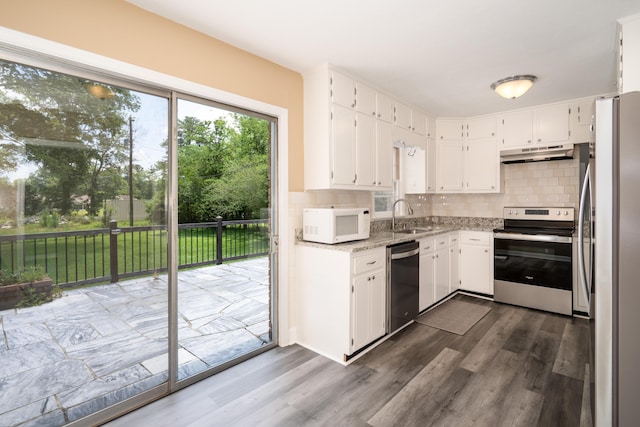 208 Wilder Rd, Chickamauga, GA 30707 - kitchen with appliances with stainless steel finishes, under cabinet range hood, dark wood-style flooring, and tasteful backsplash