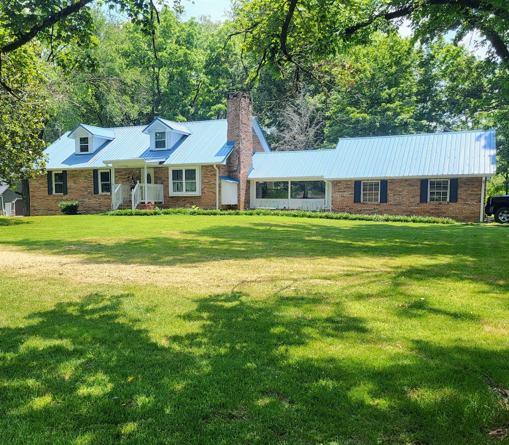 296 Davis Ln NW, Cleveland, TN 37312 - cape cod-style house featuring a chimney, a porch, a front lawn, and a metal roof