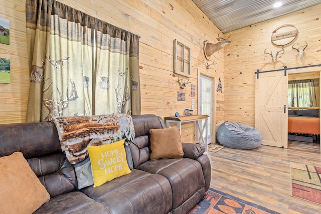1780 Wolf Haven Rd, Spencer, TN 38585 - living area with wooden walls, wood finished floors, a barn door, and a towering ceiling