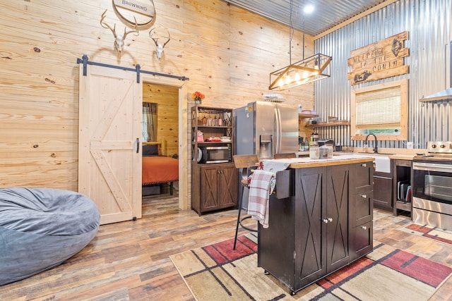 1780 Wolf Haven Rd, Spencer, TN 38585 - kitchen with stainless steel range with electric cooktop, a barn door, light wood finished floors, a center island, and wooden walls