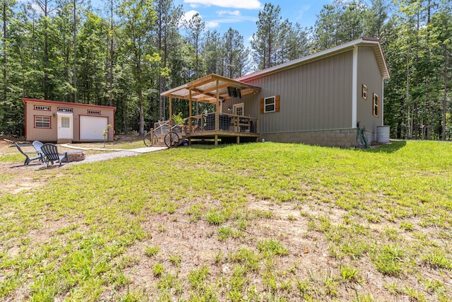 1780 Wolf Haven Rd, Spencer, TN 38585 - rear view of house featuring a deck, a fire pit, a yard, a garage, and an outdoor structure