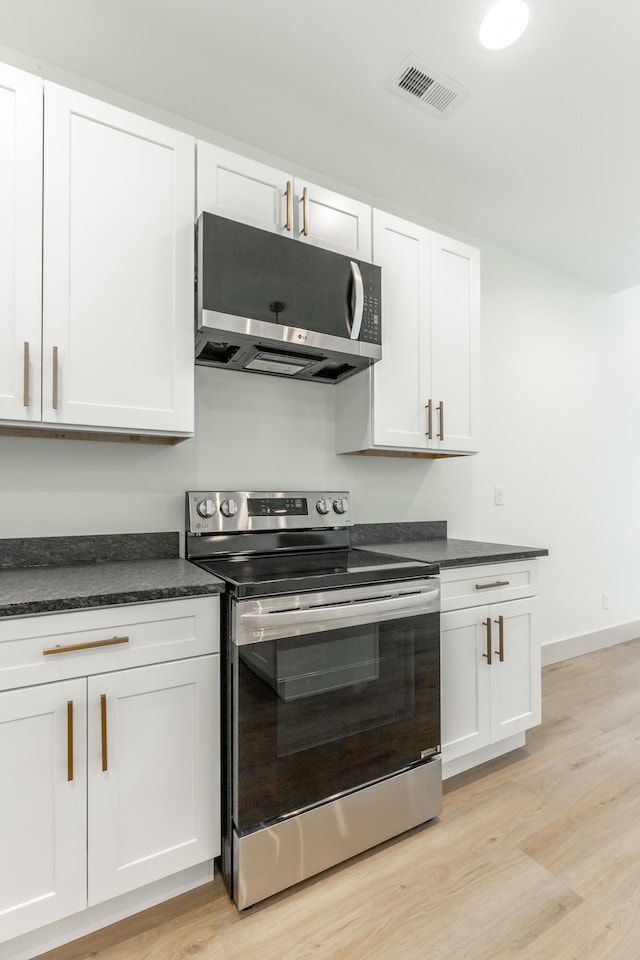581 W Reed Rd, Lafayette, GA 30728 - kitchen with electric range, dark countertops, light wood-style floors, and white cabinets