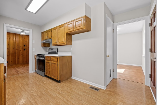3712 Norma Dr, Chattanooga, TN 37412 - kitchen featuring electric range, under cabinet range hood, light wood-type flooring, light countertops, and brown cabinetry