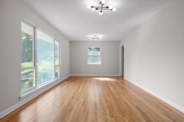 3712 Norma Dr, Chattanooga, TN 37412 - unfurnished room featuring a textured ceiling, a chandelier, and light wood-style flooring