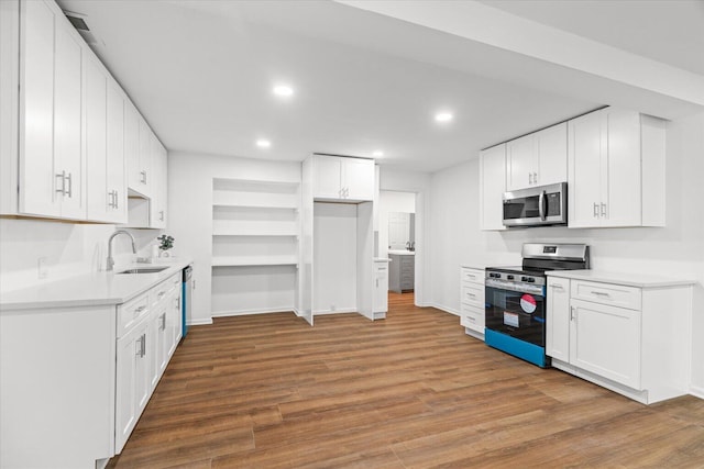 1320 Coker Dr, Dalton, GA 30721 - kitchen featuring appliances with stainless steel finishes, wood finished floors, recessed lighting, white cabinetry, and light countertops
