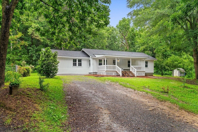 1320 Coker Dr, Dalton, GA 30721 - single story home with a porch, a shed, driveway, a front yard, and board and batten siding