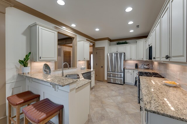 2742 Amsterdam Ln Unit 14, Chattanooga, TN 37421 - kitchen with appliances with stainless steel finishes, ornamental molding, a peninsula, a kitchen breakfast bar, and backsplash