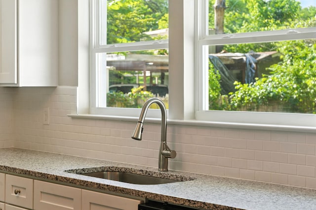 2207 Spencer Ave, Chattanooga, TN 37421 - kitchen with backsplash, light stone countertops, and white cabinetry