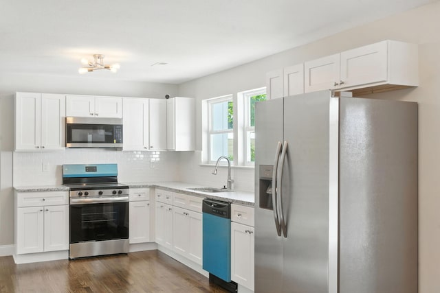 2207 Spencer Ave, Chattanooga, TN 37421 - kitchen featuring stainless steel appliances, white cabinets, tasteful backsplash, and light stone countertops