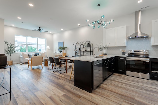 1857 Zeta Way, Chattanooga, TN 37404 - kitchen with appliances with stainless steel finishes, wall chimney exhaust hood, a peninsula, light wood-style floors, and open floor plan