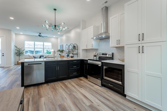 1857 Zeta Way, Chattanooga, TN 37404 - kitchen with stainless steel appliances, wall chimney range hood, a peninsula, white cabinets, and light countertops