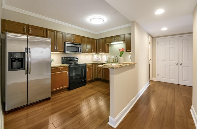 1131 Stringers Ridge Rd Unit 4C, Chattanooga, TN 37405 - kitchen with appliances with stainless steel finishes, dark wood-style floors, backsplash, light stone counters, and crown molding