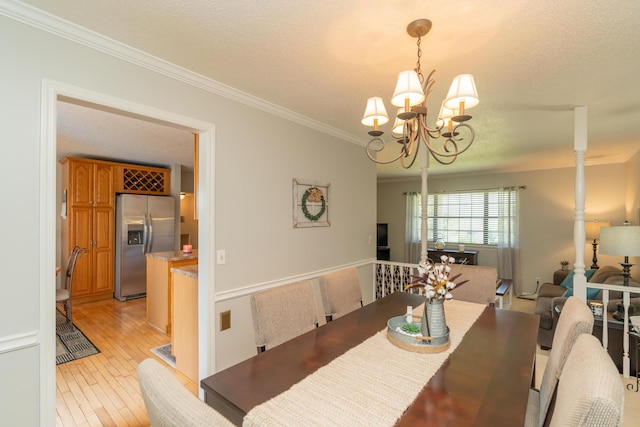 1510 Cannon Dr, Fort Oglethorpe, GA 30742 - dining room with a chandelier, crown molding, light wood-style flooring, and a textured ceiling