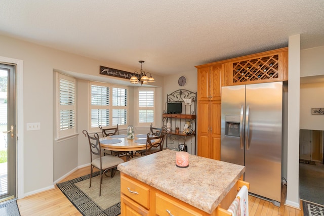 1510 Cannon Dr, Fort Oglethorpe, GA 30742 - kitchen featuring stainless steel fridge with ice dispenser, light wood finished floors, a chandelier, light countertops, and a textured ceiling