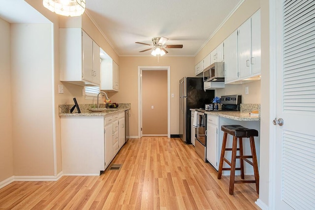 505 Heidi Cir, Chattanooga, TN 37415 - kitchen with stainless steel appliances, light wood-style flooring, a ceiling fan, white cabinets, and ornamental molding