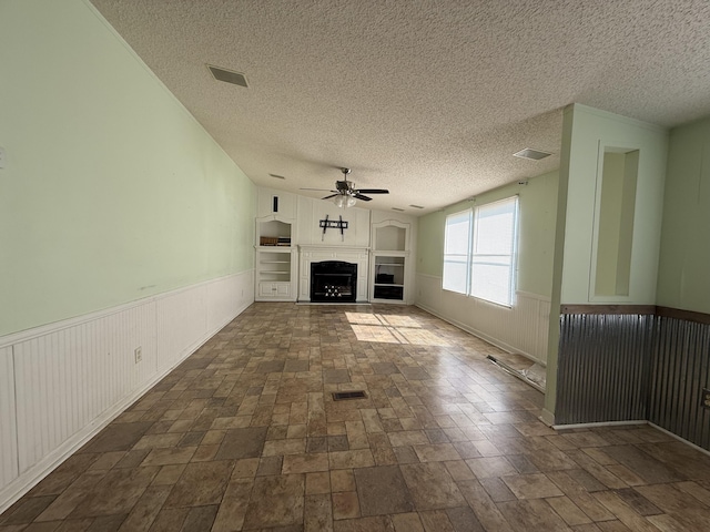 2487 Corinth Rd, Lafayette, GA 30728 - unfurnished living room with a ceiling fan, a textured ceiling, a tile fireplace, and a wainscoted wall