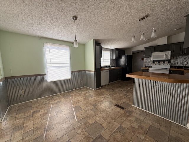 2487 Corinth Rd, Lafayette, GA 30728 - kitchen featuring white appliances, wainscoting, stone tile floors, dark countertops, and a textured ceiling